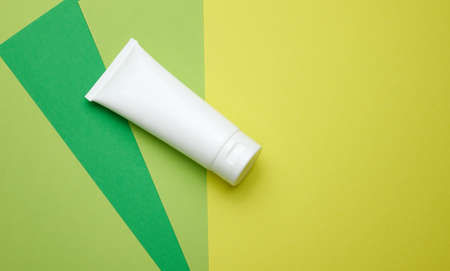 empty white plastic tubes for cosmetics. Packaging for cream, gel, serum, advertising and product promotion, green backgroundの写真素材
