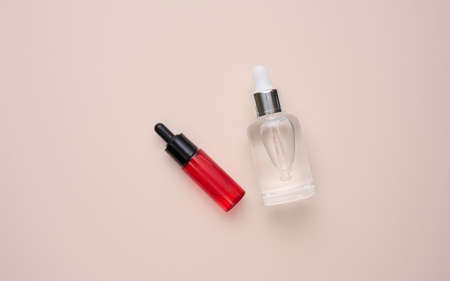 glass transparent white bottle with a pipette. Container for cosmetics, acids and oils on beige...