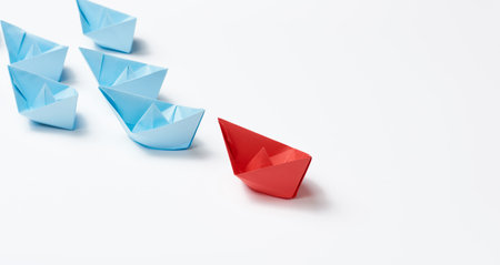 group of paper boats on a white background. concept of a strong leader in a team, manipulation of the masses, following new perspectives, collaboration and unification. Startupの写真素材