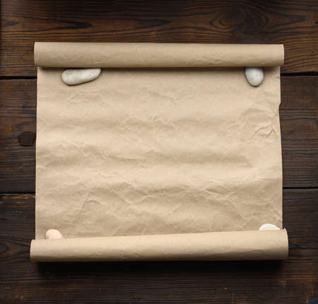 roll of brown kraft paper on a wooden background. Place for an inscriptionの写真素材