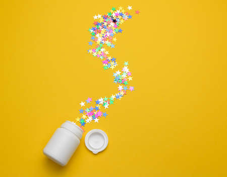 white plastic jar for pills, cream and medicines on a yellow background. Container for substances