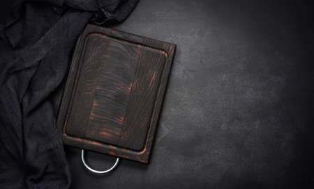 empty wooden square cutting board on black table, food display template, top viewの写真素材