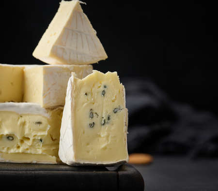brie and bergader blue cheese on a brown wooden board, delicious snack