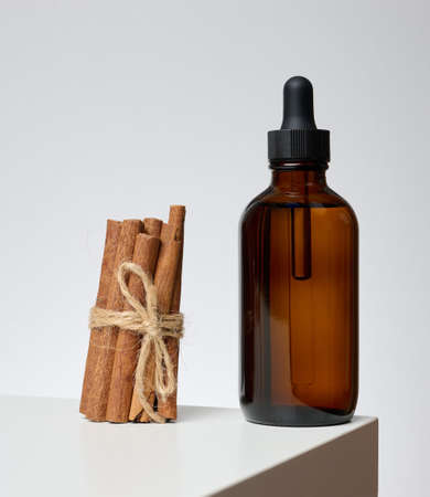 Brown glass bottle with a pipette on a gray background. Containers for cosmetics, oils, serumsの写真素材