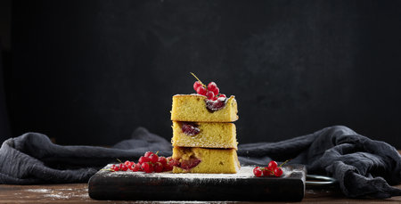 Stack of square slices of baked plum biscuit cakeの写真素材