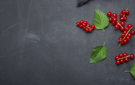 Ripe red currants in on a black table, top viewの写真素材