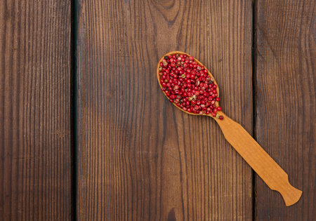 Red peppercorns in a wooden spoon on the table, spice. copy spaceの写真素材