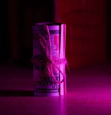 A roll of one hundred dollar bills tied with a rope. Income growth concept, high margin, profitable...