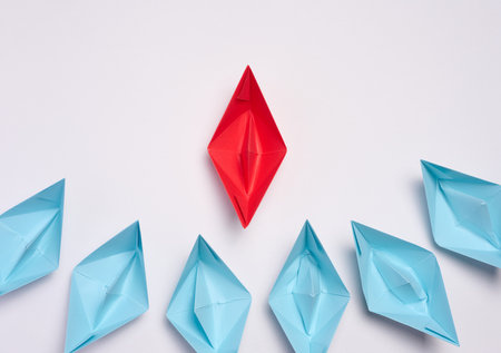 A group of blue paper boats surrounded one red boat, the concept of bullying, search for compromise. top viewの写真素材