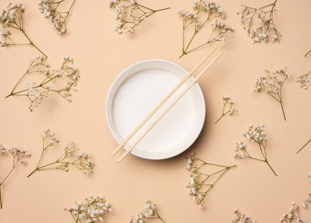 Open empty noodle bowl with and pair of wooden sticks on beige background, top viewの写真素材