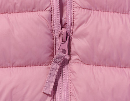 Fragment of a pink jacket with a zipper, close upの写真素材