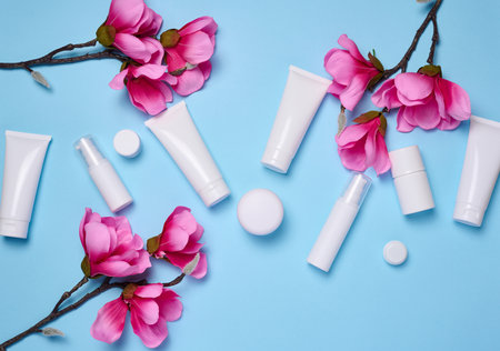 White plastic tubes, jars, and containers for cosmetic products on a blue background, advertising and branding of products, flat layの写真素材