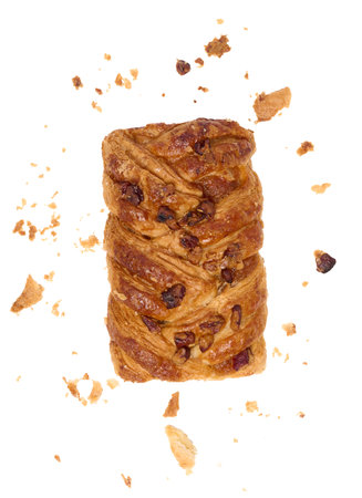 Rectangular pastry made from puff pastry with maple syrup and pecan nuts on a white background, surrounded by crumbsの写真素材