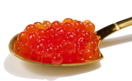 Red sturgeon caviar in a metal spoon on a white isolated background, delicious snackの写真素材