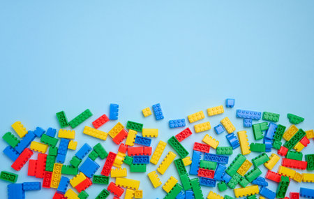 Multi-colored plastic cubes of a children's designer on a blue background, top view. copy spaceの写真素材