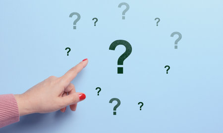 Woman's hand pointing to a question mark on a blue background. Search for an answer, find the truth