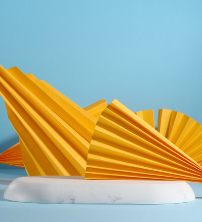 Abstract blue background with paper yellow figures, a stage for demonstrating products, cosmetics....