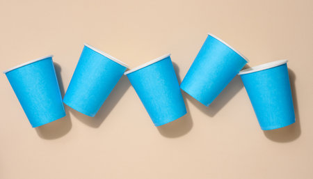 Blue disposable cups for coffee and tea on a beige background, top viewの写真素材