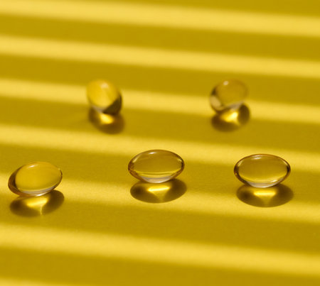 Yellow capsules with fish oil on a yellow background, close upの写真素材