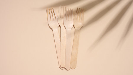 Disposable wooden forks on a beige background, top viewの写真素材