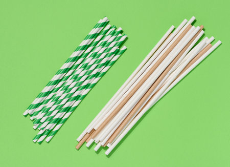 Paper cocktail straws on a green background, top viewの写真素材