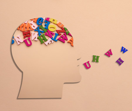 Silhouette of a human head with letters in the brain on a beige background. Concept of information processing, data analysisの写真素材