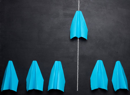 A group of paper blue airplanes with one leading ahead, concept of a strong leader.の写真素材