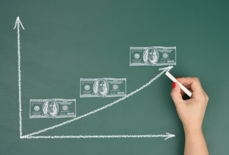 Female hand drawing an upward arrow on a graph and drawn dollars, concept of inflation growth, high...