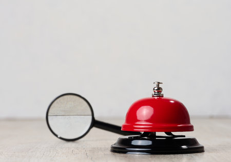 Metallic red bell to call staff on a white background, copy spaceの写真素材