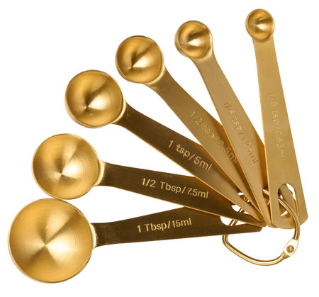 Golden metal measuring spoons for bulk and liquid products on a white isolated background, top viewの写真素材