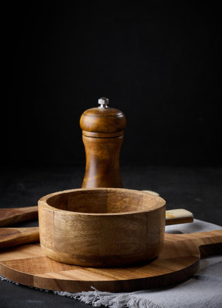 Empty bowl and wooden spoons on a black tableの写真素材