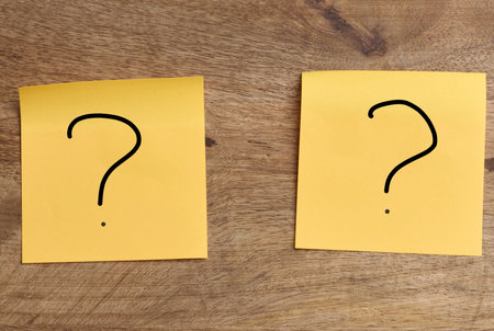 Orange stickers with a question mark on a wooden board