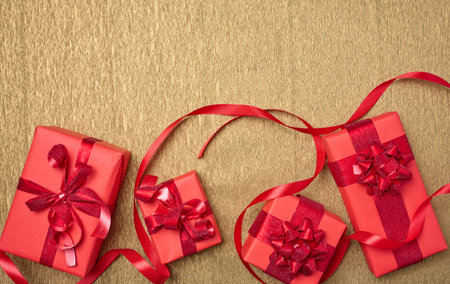 Boxes of gifts are packed in red paper on a yellow background. View from above, copy space