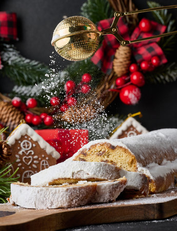 Christmas pastries stollen sprinkled with powdered sugar on the table, festive dessertの写真素材