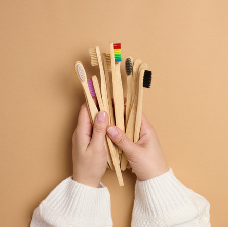 Wooden toothbrushes in female hands, top viewの写真素材