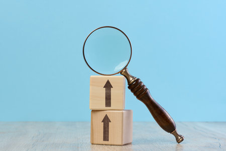 Wooden cubes and magnifying glass on blue background