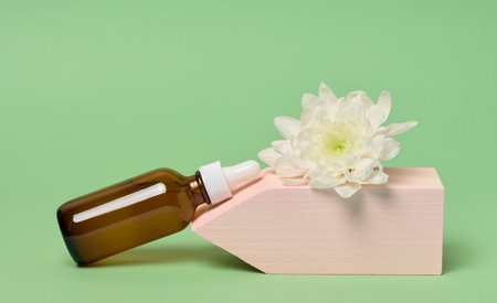 A glass brown bottle with a dropper on a green background, a container for cosmetic products.の写真素材