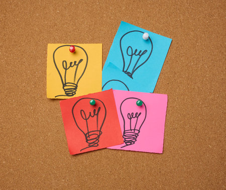 Drawn electric lightbulbs on paper sheets, signifying the concept of searching for new ideas