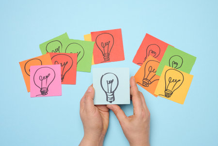 Drawn electric lamps on stickers, concept of searching for new ideas, brainstorming. Top viewの写真素材