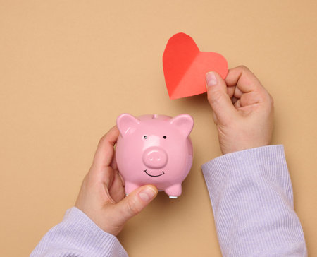 Ceramic piggy bank and red paper heart, concept of collecting love and goodnessの写真素材