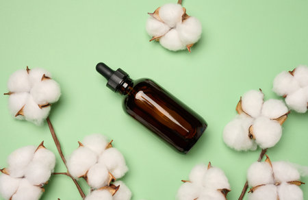 Brown glass bottle with a pipette on a green background, a container for aromatic oils and cosmeticsの写真素材