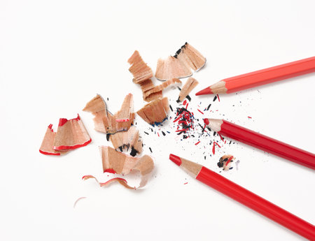 Wood shavings and red wooden pencil on white background, top viewの写真素材