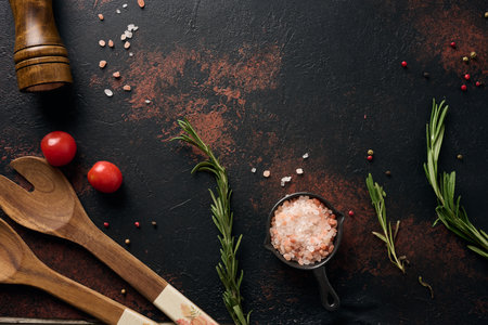 Culinary composition with kitchen utensils and spices, Himalayan salt, colorful peppercorns, fresh rosemary on the table. Top viewの写真素材