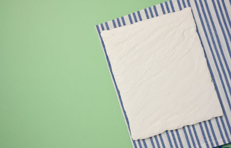 Blank square white ceramic board on green background, top viewの写真素材