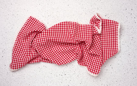 Folded red kitchen towel on a white background, top view.の写真素材