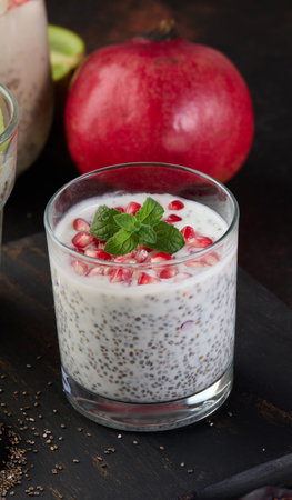 Glass of chia seeds and yogurt with pomegranate on tableの写真素材