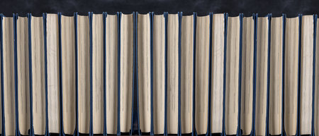 Shelf with books in a row on a black background
