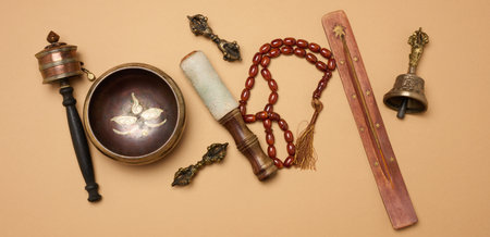 Tibetan singing copper bowl with a wooden clapper on a brown background, objects for meditation and alternative medicine, top viewの写真素材