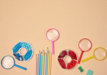 Various office and school supplies, including pencils, magnifying glasses, paper clips and pins, are...