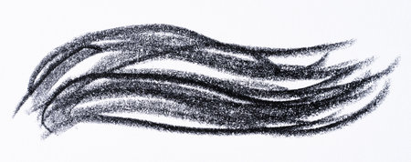 Close up of a wavy black pencil or charcoal stroke on an isolated background.の写真素材